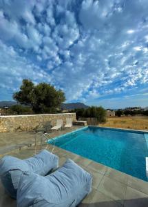 a swimming pool with pillows on a patio at Eleon Luxury Villa in Karpathos Town