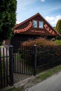 un bâtiment avec une clôture devant lui dans l'établissement Pensjonat Kaja, à Rymanów-Zdrój