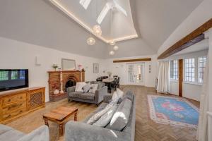 チャルフォント・セント・ジャイルズにあるNEW - Beautiful, spacious Beechwood Lodge with lovely gardensのソファとテレビのあるリビングルーム