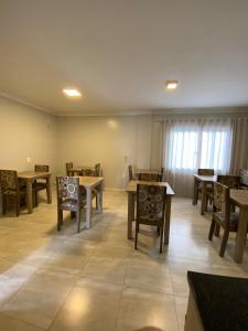 uma sala de jantar com mesas e cadeiras num quarto em North Hotel - Aeroporto em Chapecó