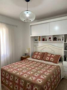 ein Schlafzimmer mit einem Bett mit einer rot-weißen Decke in der Unterkunft Sítio Vale da Colina-Nazaré Paulista - 8 pessoas in Nazaré Paulista