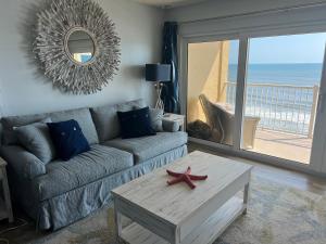 uma sala de estar com um sofá e uma estrela-do-mar numa mesa de centro em Ponce de Leon Towers em New Smyrna Beach