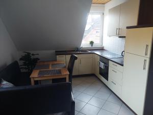 a kitchen with white cabinets and a table and a window at Ferienwohnung Schmidt in Soltau