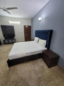 1 cama con cabecero azul en una habitación en Blue diamond guest house en Karachi