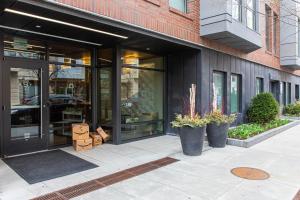 une façade de magasin avec portes et plantes en verre sur le trottoir dans l'établissement Fenway 1BR w Gym steps from Fenway Park BOS-375, à Boston