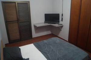AnaLuiza Smarthome في ساو جوزيه دو ريو بريتو: غرفة صغيرة تحتوي على تلفزيون وسرير