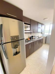 a large kitchen with a stainless steel refrigerator at Apartamento en Pereira in Pereira