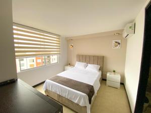 a bedroom with a large bed and a window at Apartamento en Pereira in Pereira