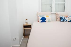 una camera da letto con un letto bianco con cuscini e una finestra di Appartement Cosy près de Paris et Disney a Neuilly-Plaisance Altre 10 foto