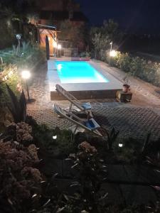 a swimming pool at night with a lounge chair next to it at Casa di sotto in Giratola