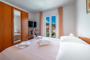 um quarto com uma grande cama branca e uma janela em Sea View, Free Parking 2br Apartment em Dubrovnik