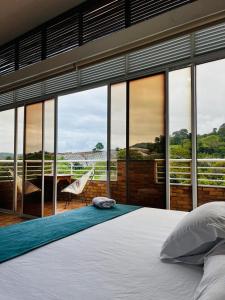 卡拉爾卡的住宿－Kai Hotel Campestre，一间卧室设有床铺和大型玻璃窗