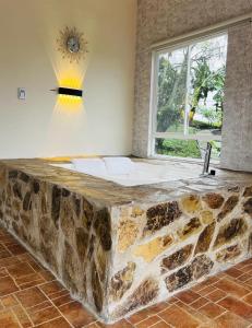 a large stone bathtub in a room with a window at Kai Hotel Campestre in Calarcá