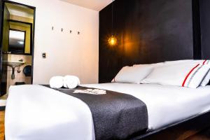 una camera da letto con un grande letto bianco con cuscini bianchi di Hotel Panorama Center a Medellín