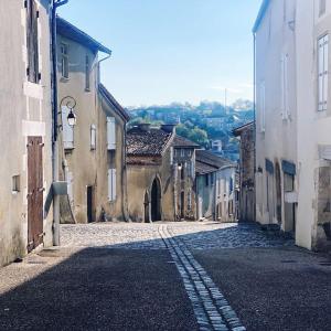 an empty street in an old town with buildings at Le Prieuré du Vigeant in Le Vigeant