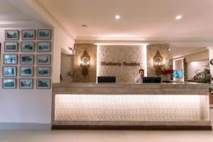 Shelton Rezidor House Peshawar في بيشاور: امرأة تقف عند مكتب الاستقبال في غرفة انتظار المرضى