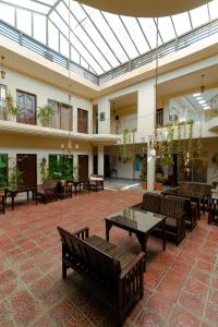 Shelton Rezidor House Peshawar في بيشاور: لوبي فارغ فيه كراسي وطاولات وسقف زجاجي