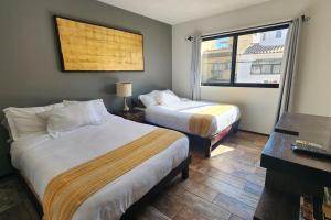 圣米格尔-德阿连德Mateo place ideal for your next visit to San Miguel的一间卧室，有两张床、一张书桌和一扇窗户