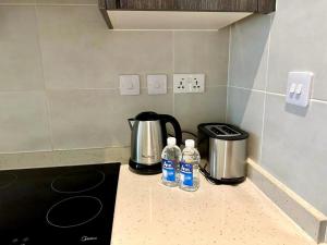 a kitchen counter with two bottles of water on it at A007 Embassy Gardens Studio Apartm in Accra