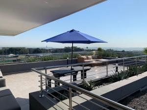 un patio con una mesa y una sombrilla en el techo en Summer Square, Umhlanga Ridge, en Durban