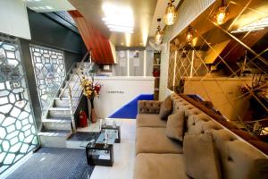 a living room with couches and stairs in a building at N.M. Hotel in Mumbai