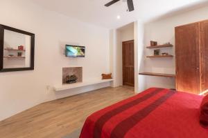a bedroom with a bed with a red blanket at Casita Victoria in San Miguel de Allende