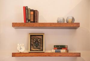 a shelf with a picture and a clock and books at Casita Victoria in San Miguel de Allende