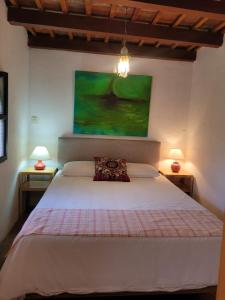 a bedroom with a white bed with two lamps at 2 Pilas: historic colonial house in Antigua Guatemala