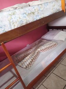 a bunk bed with a coil of rope on it at Pousada paraíso no Mar in Matinhos