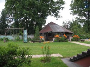 a pavilion in a park with flowers in the yard at Umichala in Mściszewice