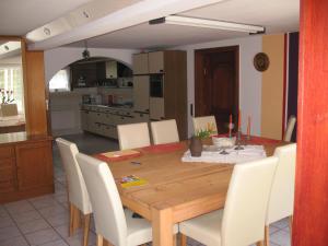 a dining room with a wooden table and white chairs at Umichala in Mściszewice +19 photos