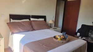 Un dormitorio con una cama con una bandeja de comida encima. en Apartamento flat em Serra Negra - 12A, en Serra Negra