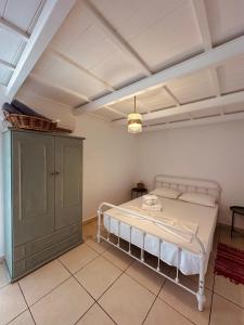 a bedroom with a white bed and a cabinet at Eleon Luxury Villa in Karpathos Town