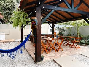 a patio with a hammock and tables and chairs at Sagui Hostel in Florianópolis