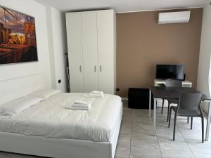 een slaapkamer met een bed, een tafel en een televisie bij APPARTAMENTO FIERA MILANO - Affitti brevi Italia in Pero