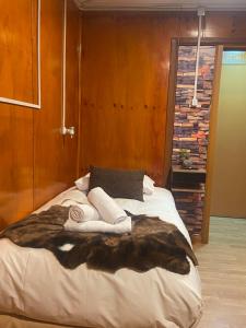 a bedroom with a large bed with a faux fur blanket at Hostal Queltehue in Ancud