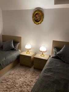a bedroom with two beds and two lamps on tables at Sara Apartament in Lugoj