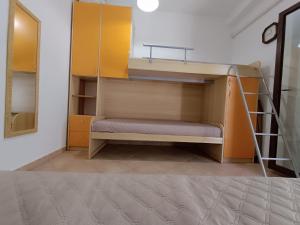 Al Porto, casa vacanze 100mt dal mare في مارينا بورتو: غرفة مع سرير بطابقين مع سلم