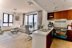 eine Küche und ein Wohnzimmer mit einem Sofa in der Unterkunft MAJESTIC LE PONT PORT DE LA MER FULL SEA VIEW-Jumeirah1-Dubai in Dubai