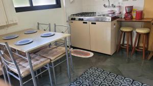 a kitchen with a table with chairs and a stove at Piemonte Flat Serra Negra in Serra Negra