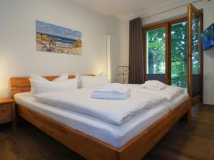 - une chambre avec un grand lit et des draps blancs dans l'établissement Holiday apartment 2-room apartment with 1 bedroom and terrace DG22, à Heringsdorf