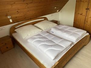 uma cama de madeira com duas almofadas num quarto em Country house on Silbersee em Frielendorf