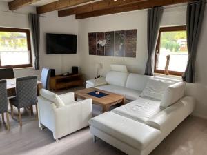 uma sala de estar com um sofá branco e uma mesa em Country house on Silbersee em Frielendorf