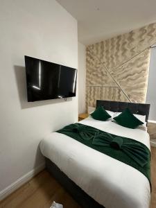 a bedroom with a large bed with a flat screen tv on the wall at Ariana House Hotel-Families and Couples Only in Blackpool