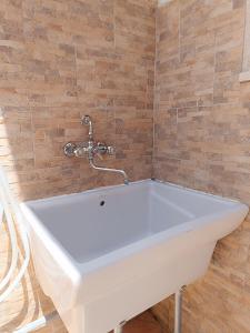 Al Porto, casa vacanze 100mt dal mare في مارينا بورتو: حمام مع حوض أبيض وكرسي