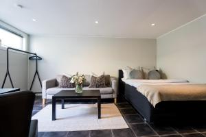 um quarto com uma cama, um sofá e uma mesa em Apartment on idyllic Bygdøy with free parking em Oslo