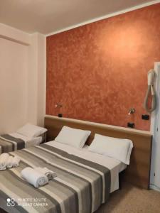 2 Betten in einem Hotelzimmer mit Handtüchern darauf in der Unterkunft Hotel Prestige 3 Stars in Rimini