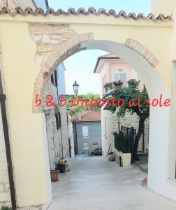 an archway in a white building with a house at B&B Un posto al Sole in Numana