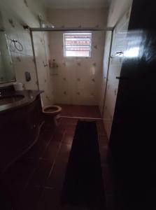 a bathroom with a toilet and a sink and a window at Pousada Casa dos Gattos - Próx ao Aeroporto Guarulhos in Guarulhos