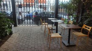 a patio with tables and chairs in front of a gate at Pousada Casa dos Gattos - Próx ao Aeroporto Guarulhos in Guarulhos